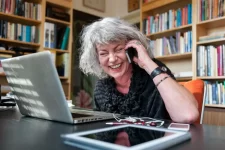 Vrouw het een gsm-abonnement waarmee ze onbeperkt belt terwijl ze werkt op haar laptop.