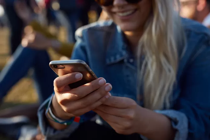 Vrouw verbruikt mobiele data terwijl ze haar social media op haar smartphone bekijkt.