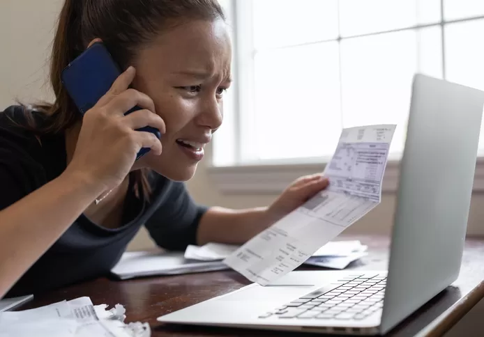 Vrouw zit voor haar computer en checkt of ze in aanmerking komt voor het sociaal tarief.