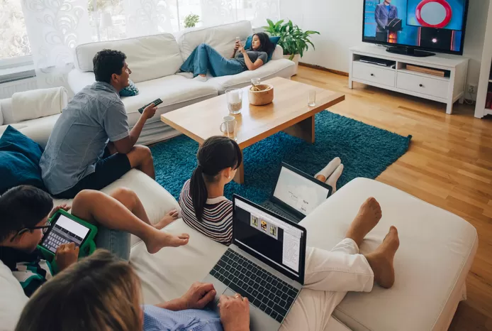 Vrienden kijken dankzij het aanschaffen van een telecompakket samen naar tv.