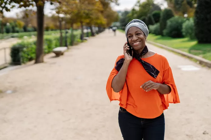 Vrouw belt via mobiel terwijl ze jogt in het park