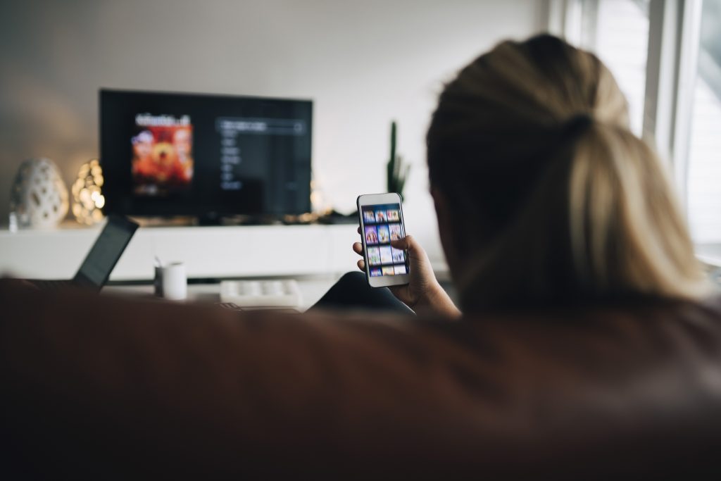 Vrouw kijkt Netflix in haar zetel.