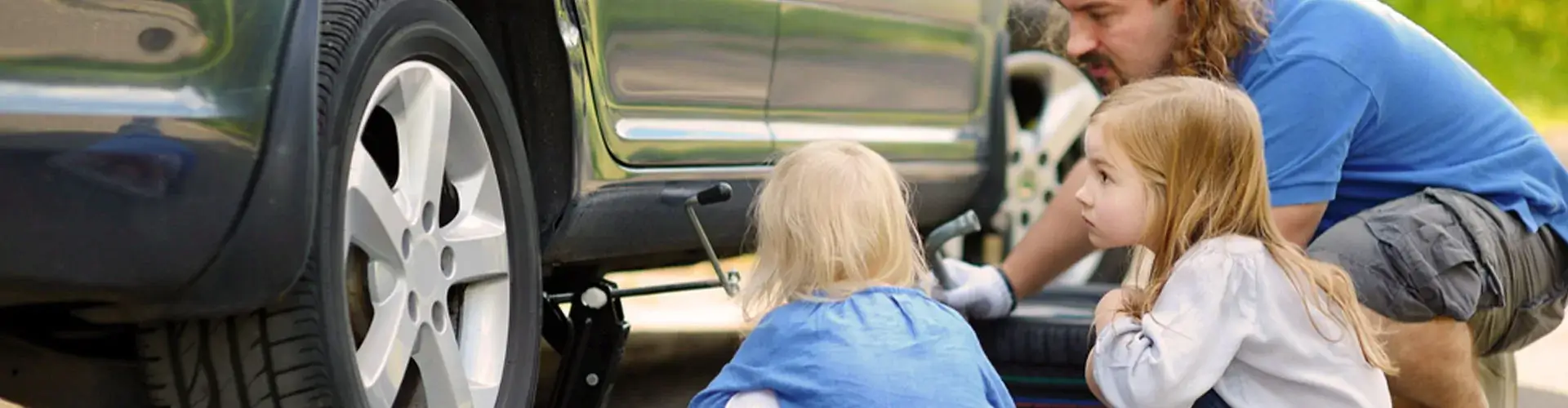 Kinderen kijken naar hoe vader auto repareert