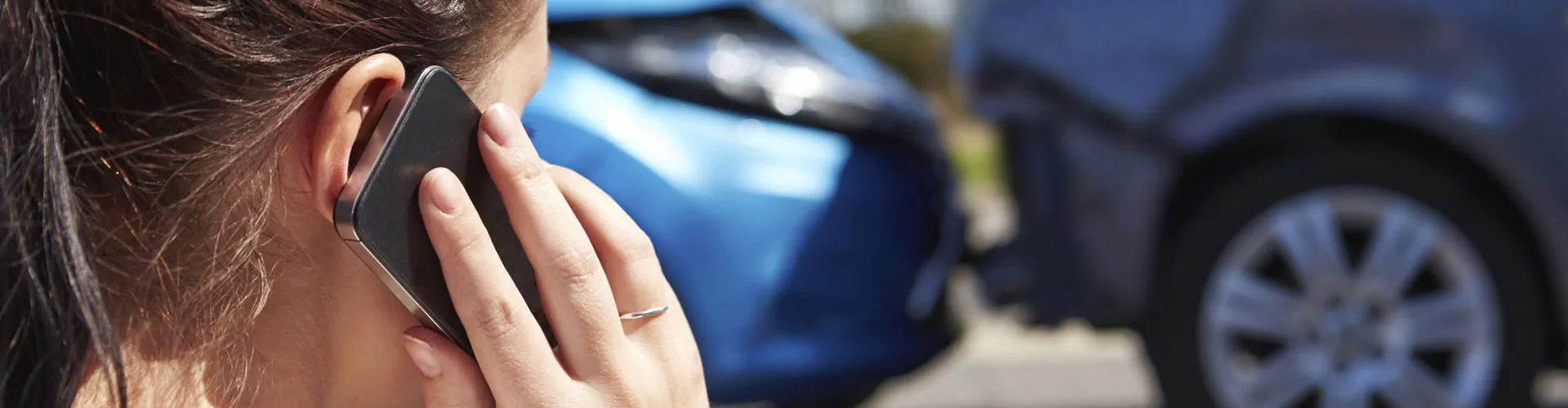 Vrouw belt met smartphone tijdens auto-ongeluk.