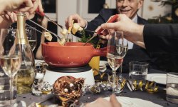 Familie eet fondue tijdens de feestdagen.