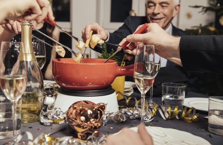 Familie eet fondue tijdens de feestdagen.