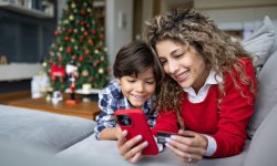 Mama en zoon zijn tijdens de kerstvakantie samen thuis en surfen op smartphone.