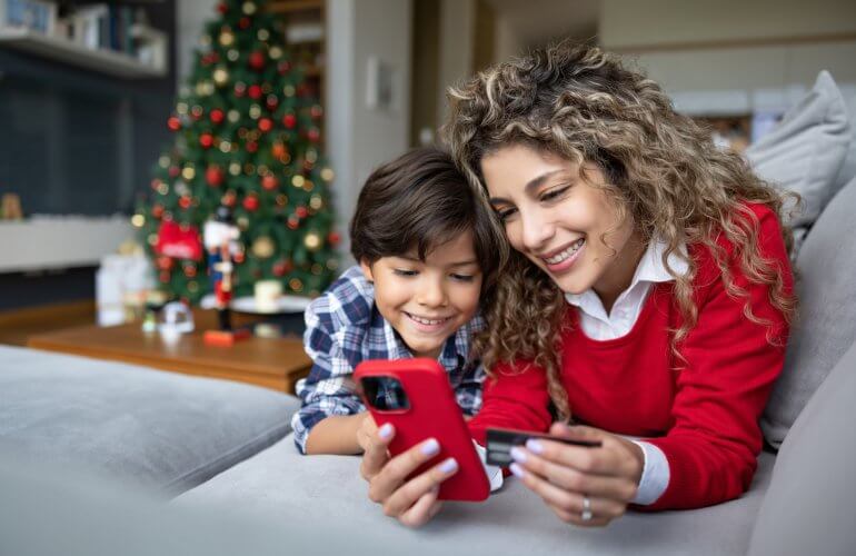 Mama en zoon zijn tijdens de kerstvakantie samen thuis en surfen op smartphone.