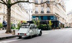 Lichtblauwe oldtimer staat in de zomer met opendak op straat in Parijs.