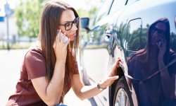 Vrouw ontdekt schade aan haar geparkeerde wagen en belt verzekeraar.