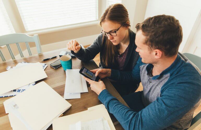 Koppel bekijkt via hun smartphone of ze aanspraak kunnen maken op het sociaal telecomtarief.